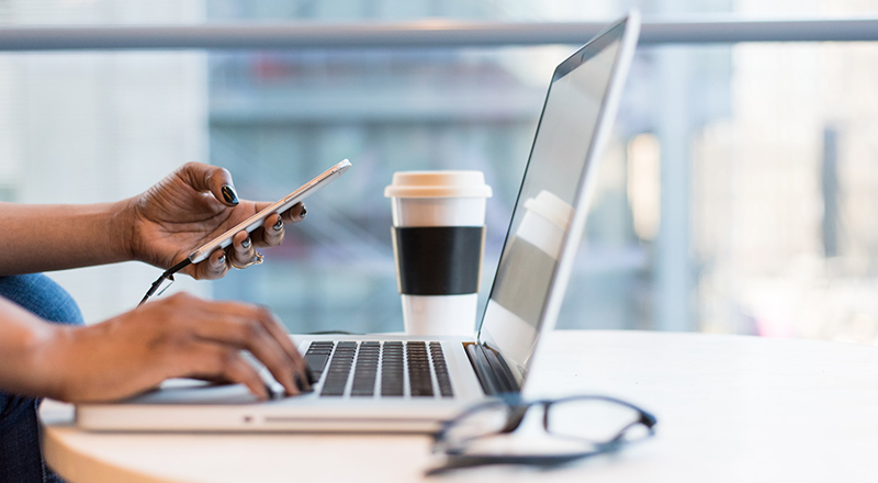 Person using phone and laptop