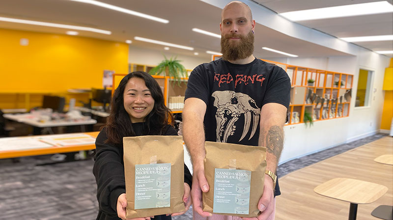 two students holding packages