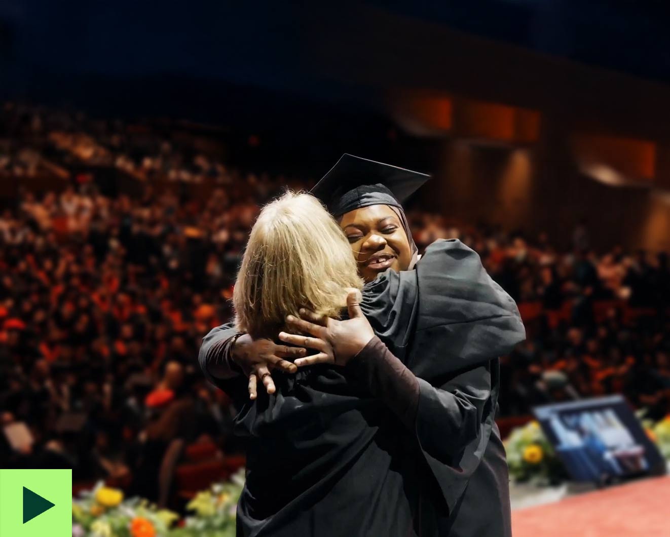 VCC grad hugging a presenter during a convocation ceremony.