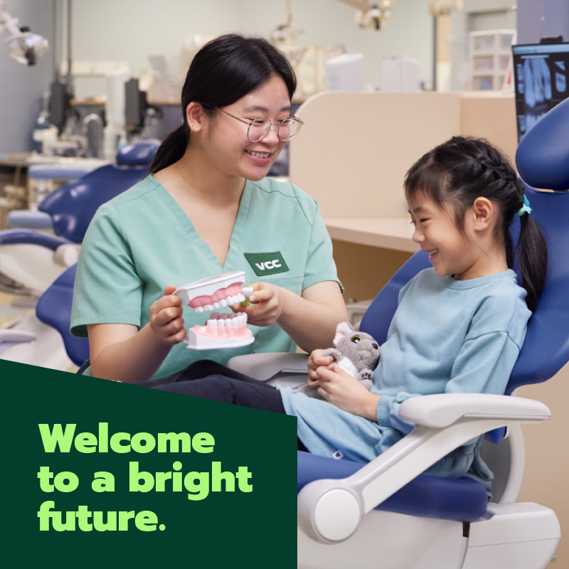 dental student teaching a child how to brush teeth properly