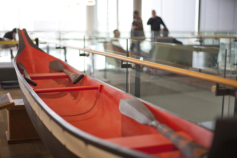 A red canoe with people in the backround