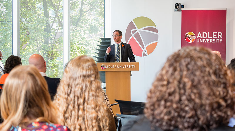 AVP Clayton Munro speaking at partnership signing with Adler