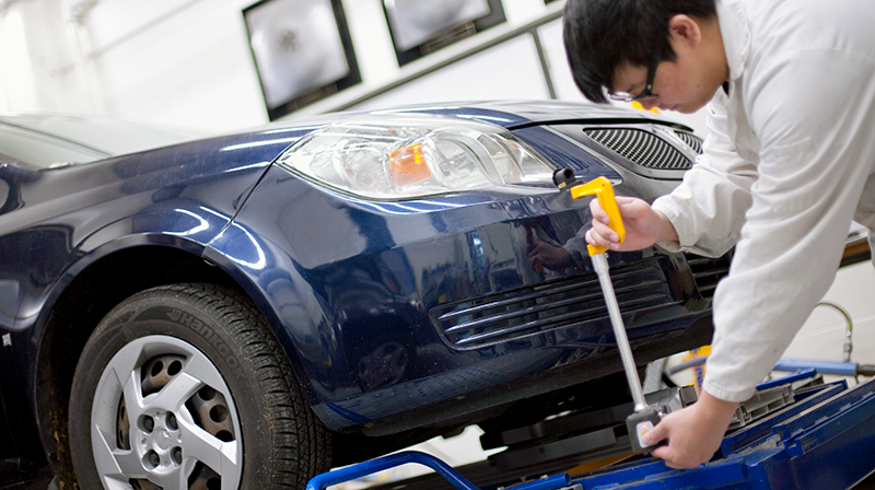VCC automotive student measuring blue car bumper