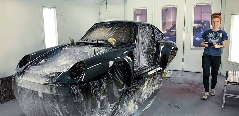 Jolene Orr in paint booth with black porsche